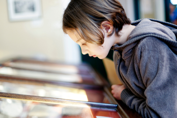 enfant dans musee qui regarde vitrine